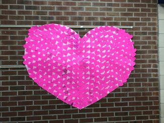 A heart made of post-it notes written on by students welcomes guests to Central Elementary.
