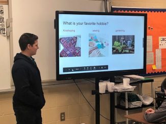 A student is shown using technology to present his biography project.