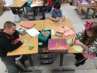Students are shown cutting out valentine's day cards for St. Jude's children.