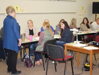 Teachers are shown learning about on demand writing techniques by trainer Abell and Atherton.