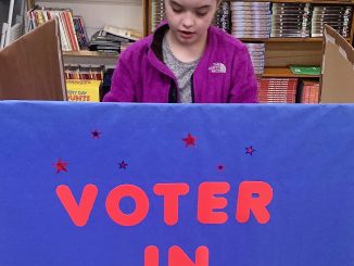 A student is shown voting in the 4th grade election at Lay.