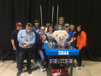 The Lynn Camp Wildbots Robotics Team poses for a photo with their robot during competition.