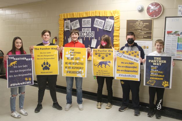 Students at KCMS show off posters that they designed with positive behavior messages.